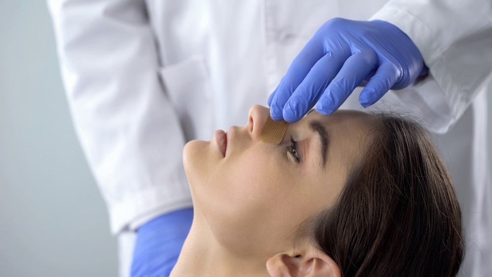 Doctor examining patient for a fractured nose